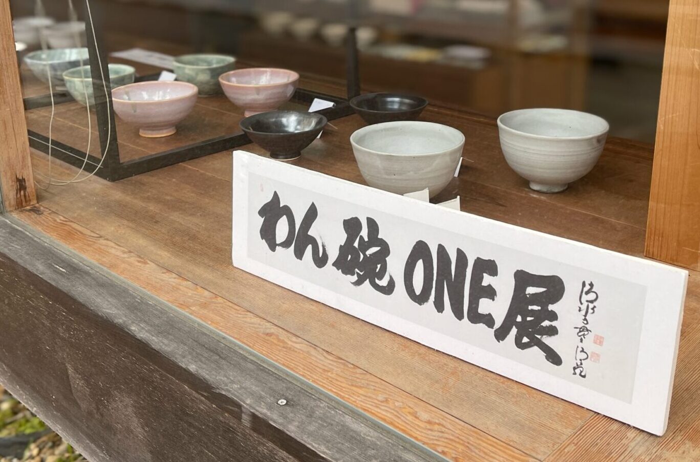 わん碗ONE展のショーウィンドウ（陶器と「わん碗ONE展」の案内）